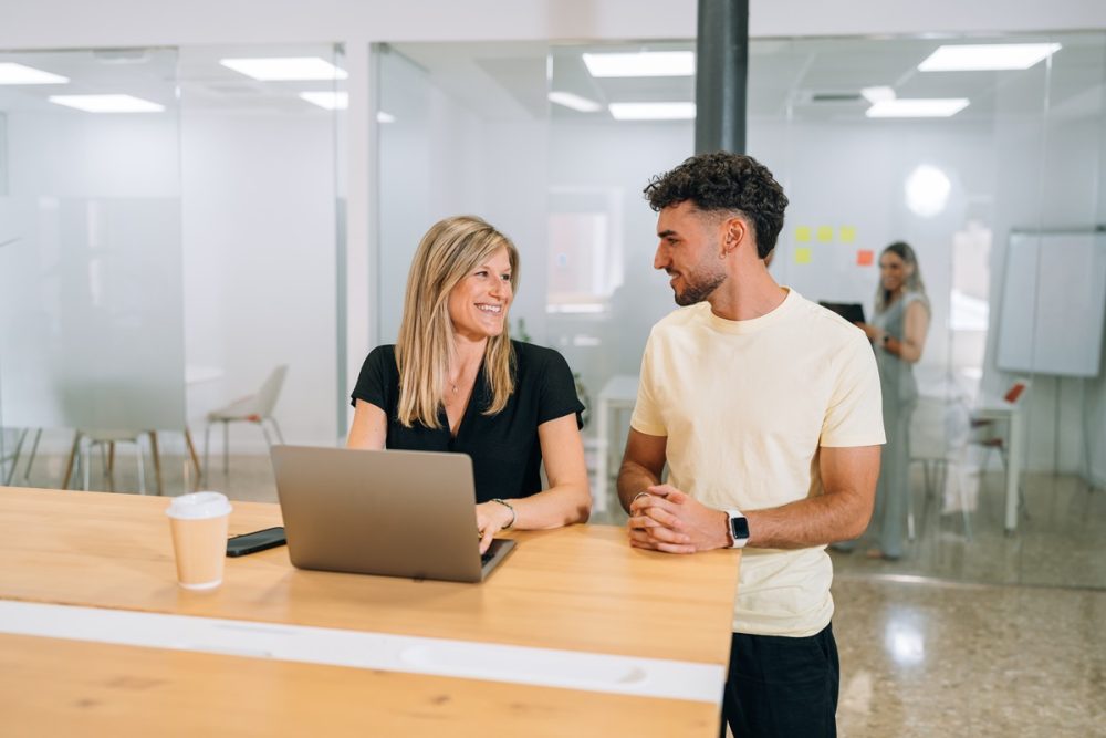 Persona descansando con una taza de café mientras trabaja, representando el equilibrio entre trabajo y vida personal.