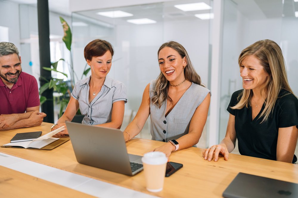 Freelance sentado en su espacio de trabajo con portátil, mostrando una sensación de desconexión o pausa.
