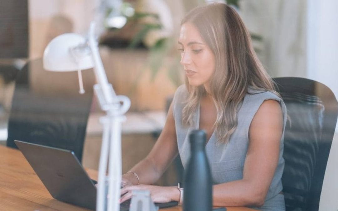 Persona trabajando en un espacio de coworking con portátil, en un entorno moderno y colaborativo para freelancers.