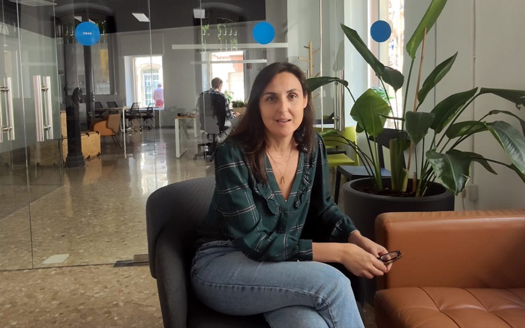 Interior de un espacio de coworking moderno con zonas de trabajo abiertas, luz natural y ambiente profesional