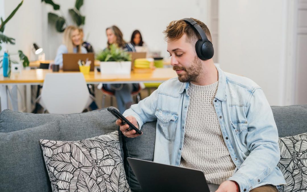 Sala de coworking con varias personas trabajando en silencio alrededor de una mesa grande en un espacio luminoso.