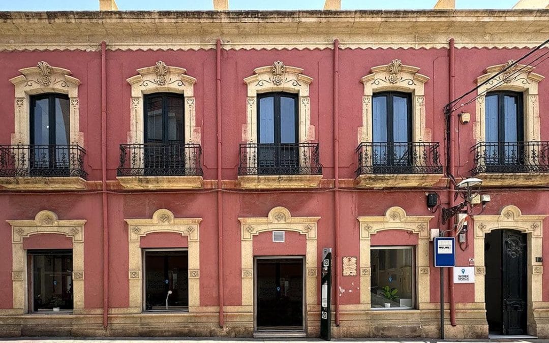 Fachada de edificio histórico en el centro de Almería con balcones de forja y ventanas restauradas