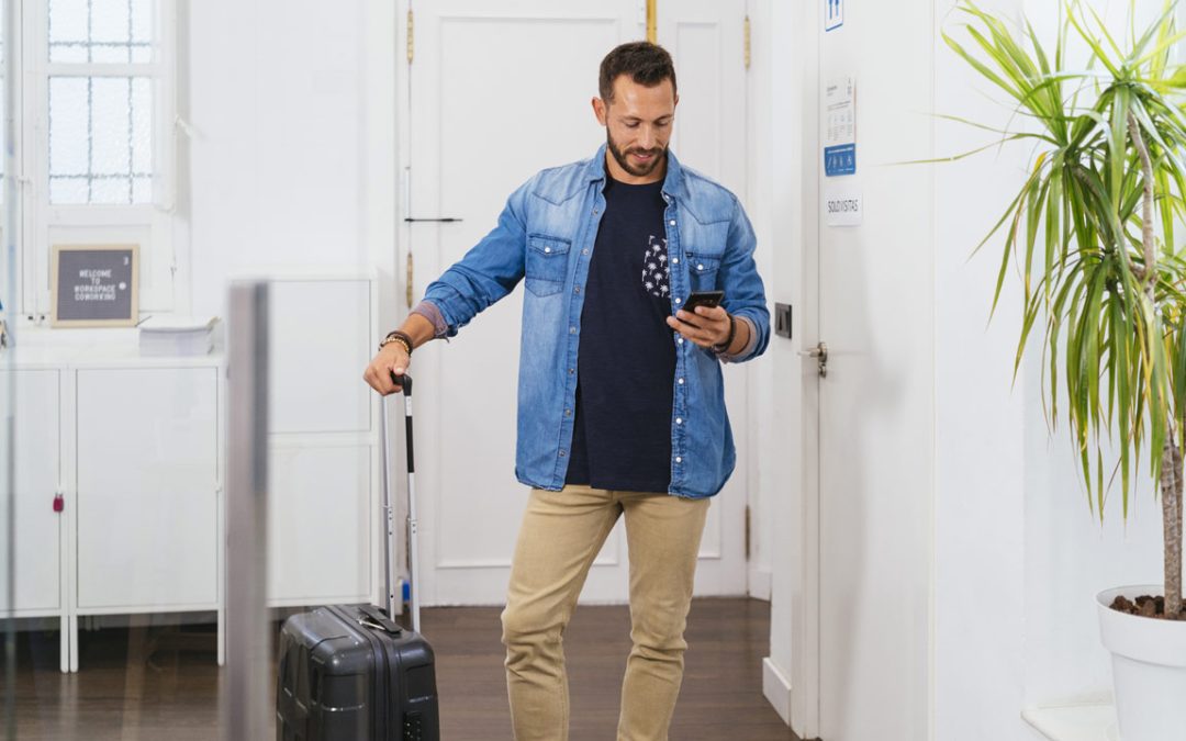 Profesional llegando a un coworking con maleta en su primer día de trabajo