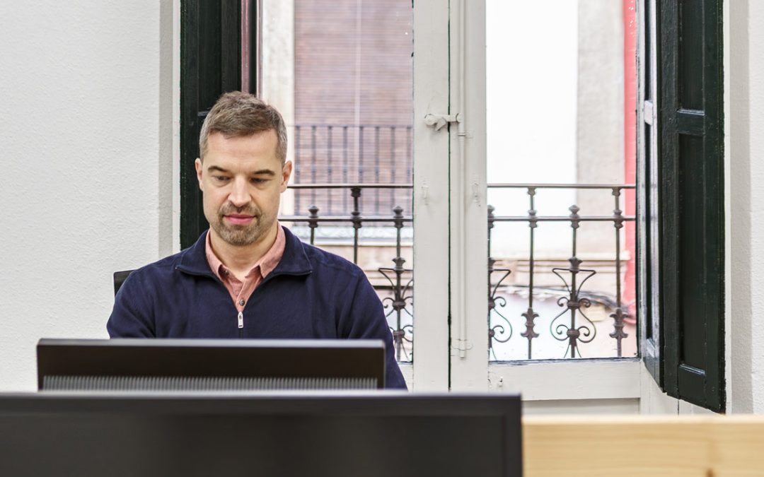 Profesional trabajando con ordenador en un coworking luminoso en Almería
