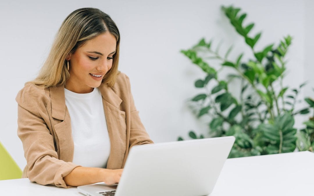 Teletrabajadora usando un portátil en un coworking luminoso y profesional