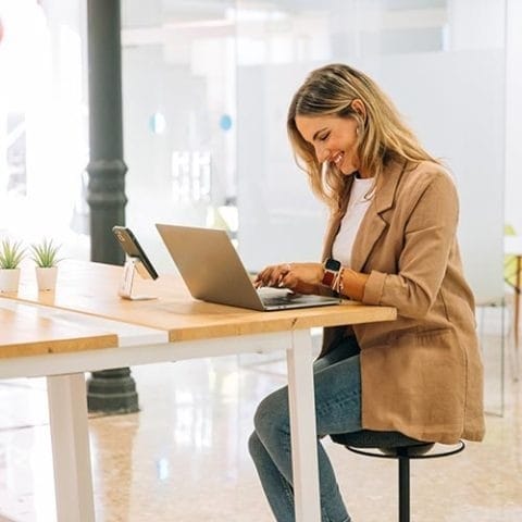 Puestos flexibles y pases por días en Workspace Almería Profesional trabajando con portátil en puesto flexible de Workspace Coworking Almería