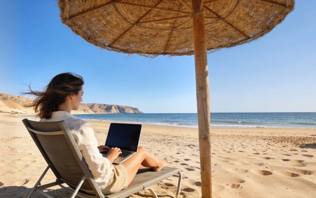 Persona teletrabajando con portátil en una playa de Almería, una de las ciudades más felices de España