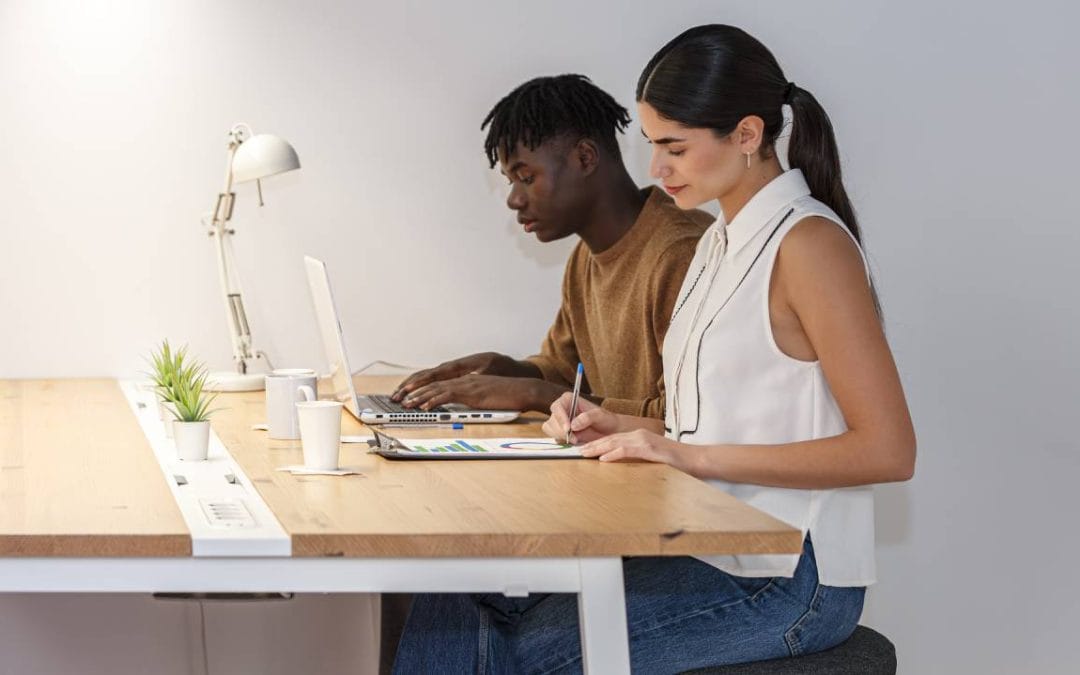 Dos profesionales trabajando en una mesa compartida de coworking en Almería